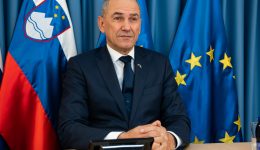 Slovenia PM in front of country flag